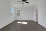 primary bedroom with windows and hard surface flooring
