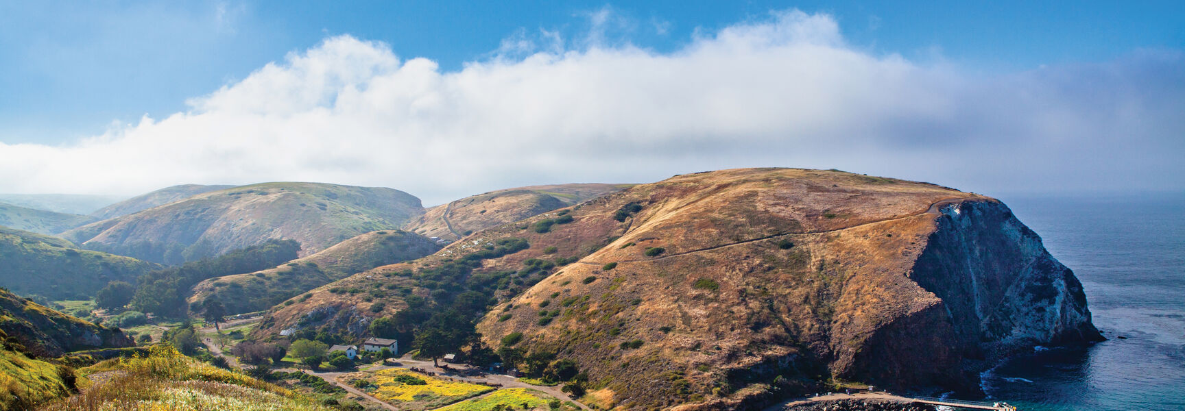 Scenic view of rolling hills and a pier along the coastline of Channel Islands National Park in California.