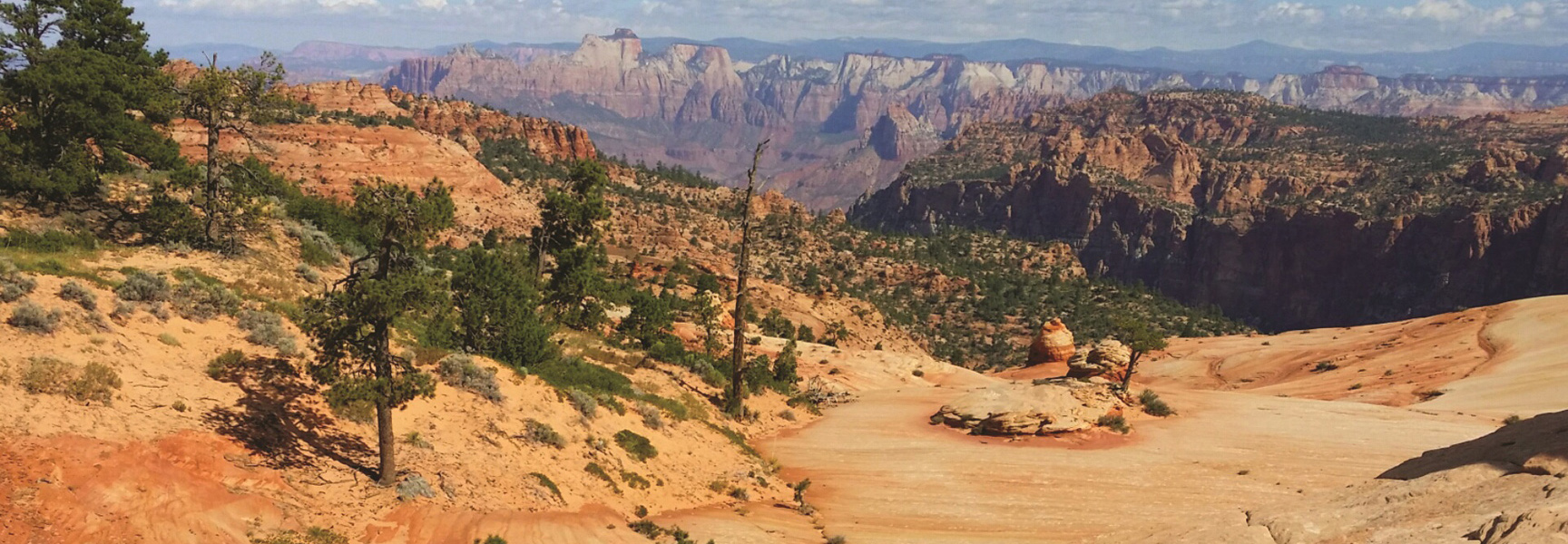 A scenic view of the rugged, red rock canyons and desert landscape of a backcountry trail in southwestern Utah.