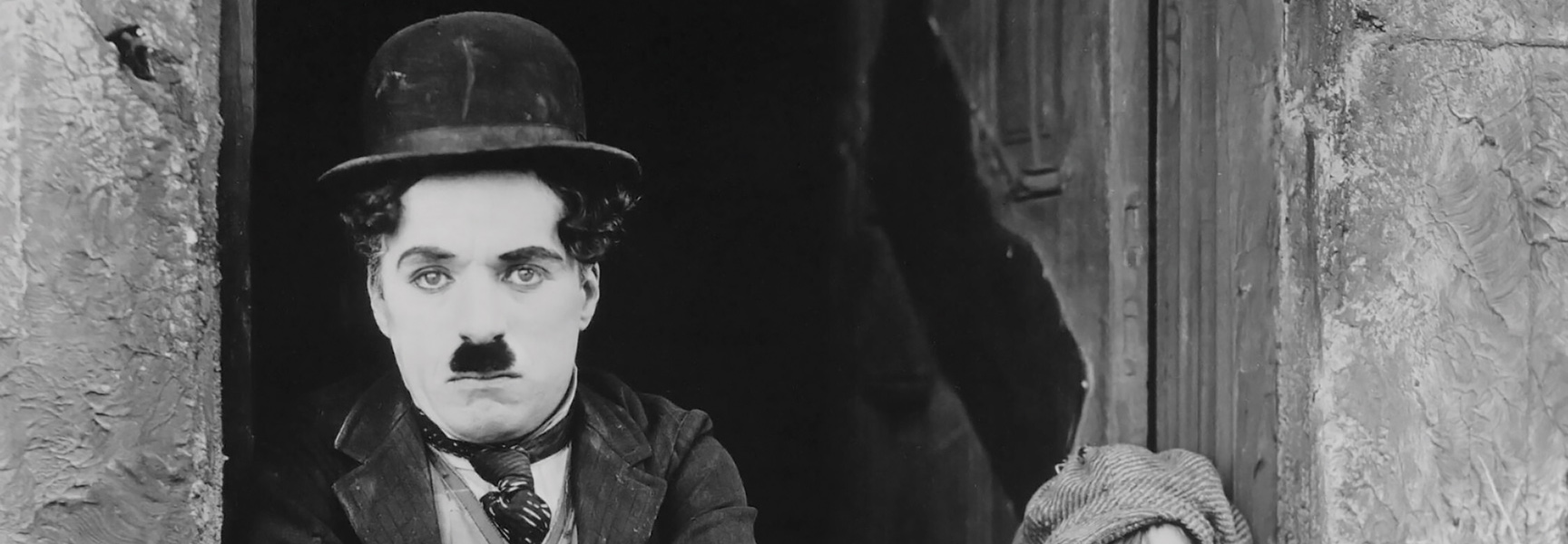 A black and white close-up of Charlie Chaplin in character for a silent film comedy event in Georgia.