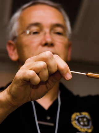 Forensic expert Steven Staggs demonstrates evidence collection by applying a solution to a swab during an introduction to crime scene investigation course.