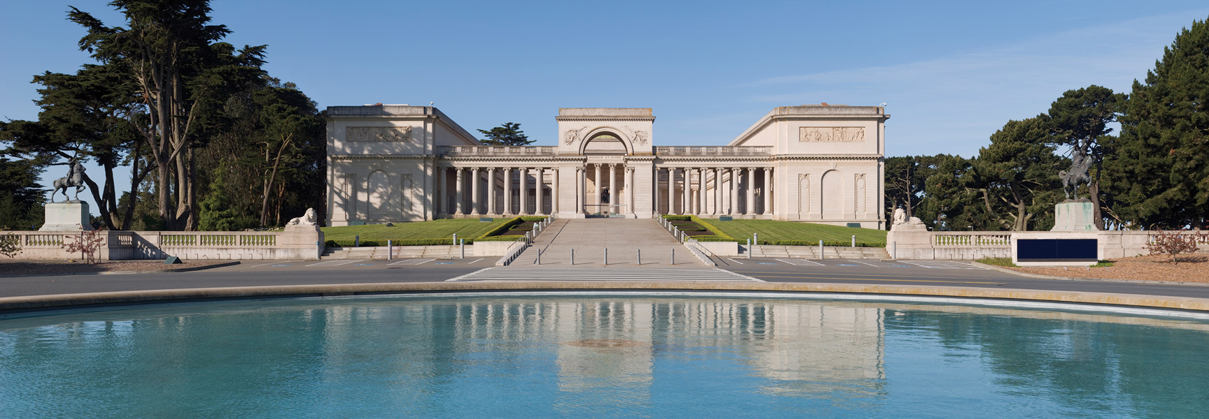 The Legion of Honor museum in San Francisco, California, seen from across its reflecting pool on a sunny day.