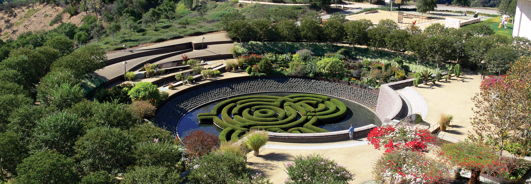 An aerial view of the Central Garden at the Getty Center in California, featuring a floating hedge maze in a circular pool.