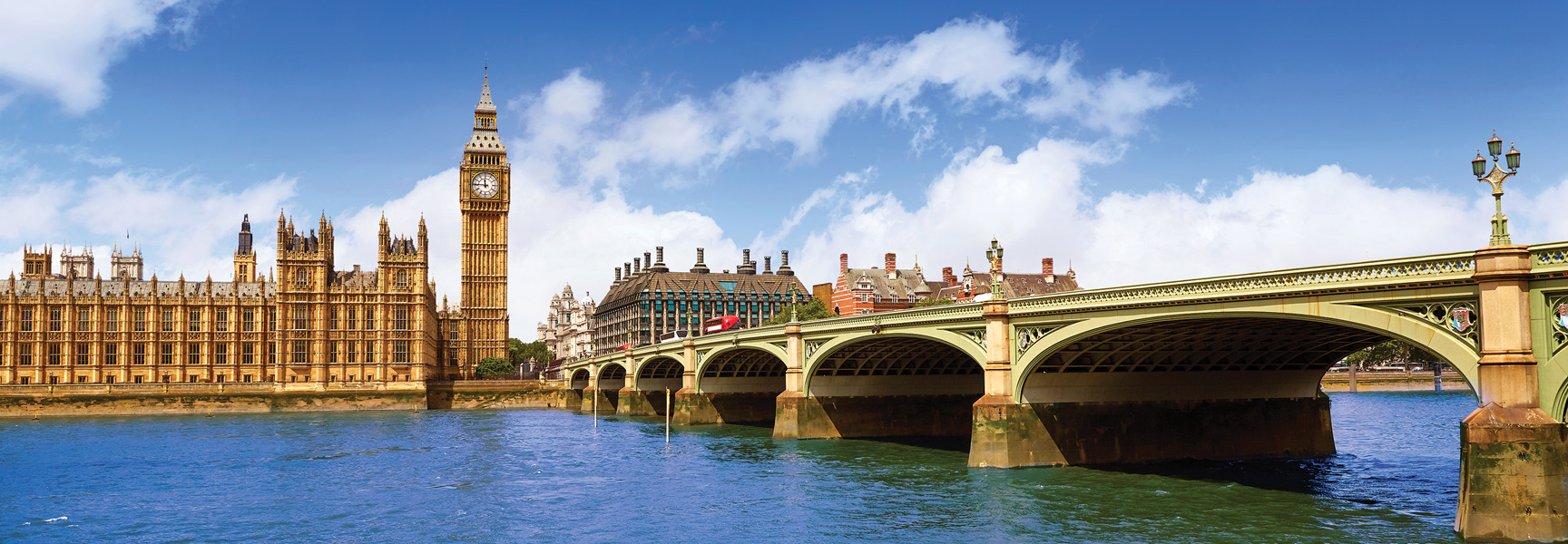 A scenic view of the Houses of Parliament, Big Ben, and Westminster Bridge over the River Thames in London, England on a sunny day.