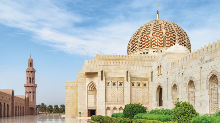 The Sultan Qaboos Grand Mosque in Oman features an ornate golden dome and minaret, showcasing the region's rich Arabian history and heritage.