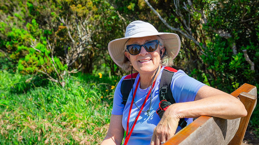 A woman smiles while sitting on a bench during a hike in Costa Rica.