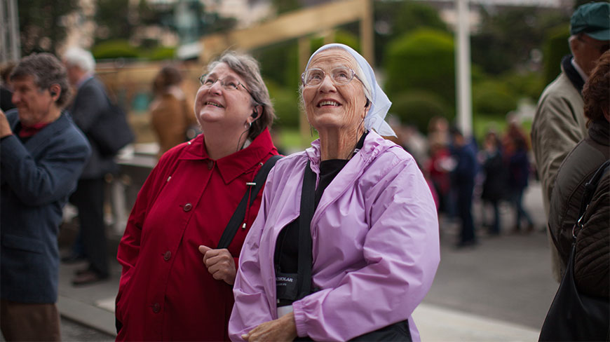 Carol Elbert and Linda look up and smile while standing outside the Kunsthistorisches Museum in Vienna.