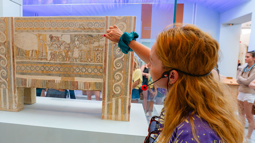 A woman points at an ancient painted sarcophagus on display at the Archaeological Museum of Heraklion in Crete.