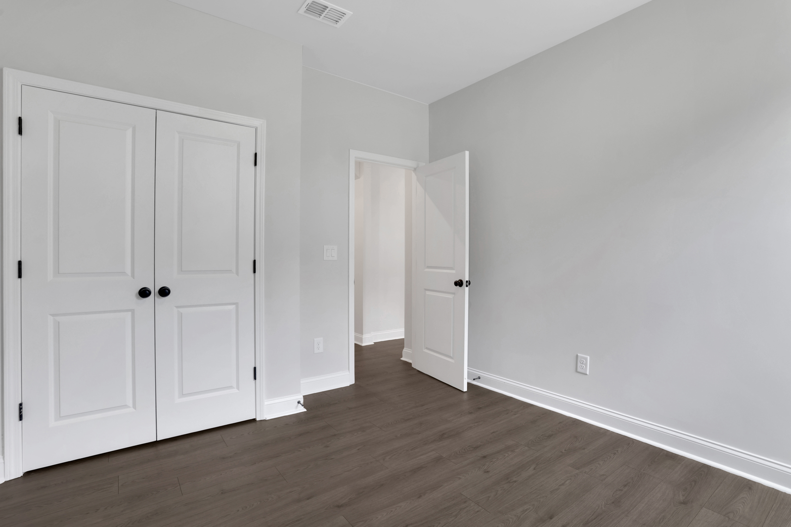 secondary bedroom with hard surface floors and windows