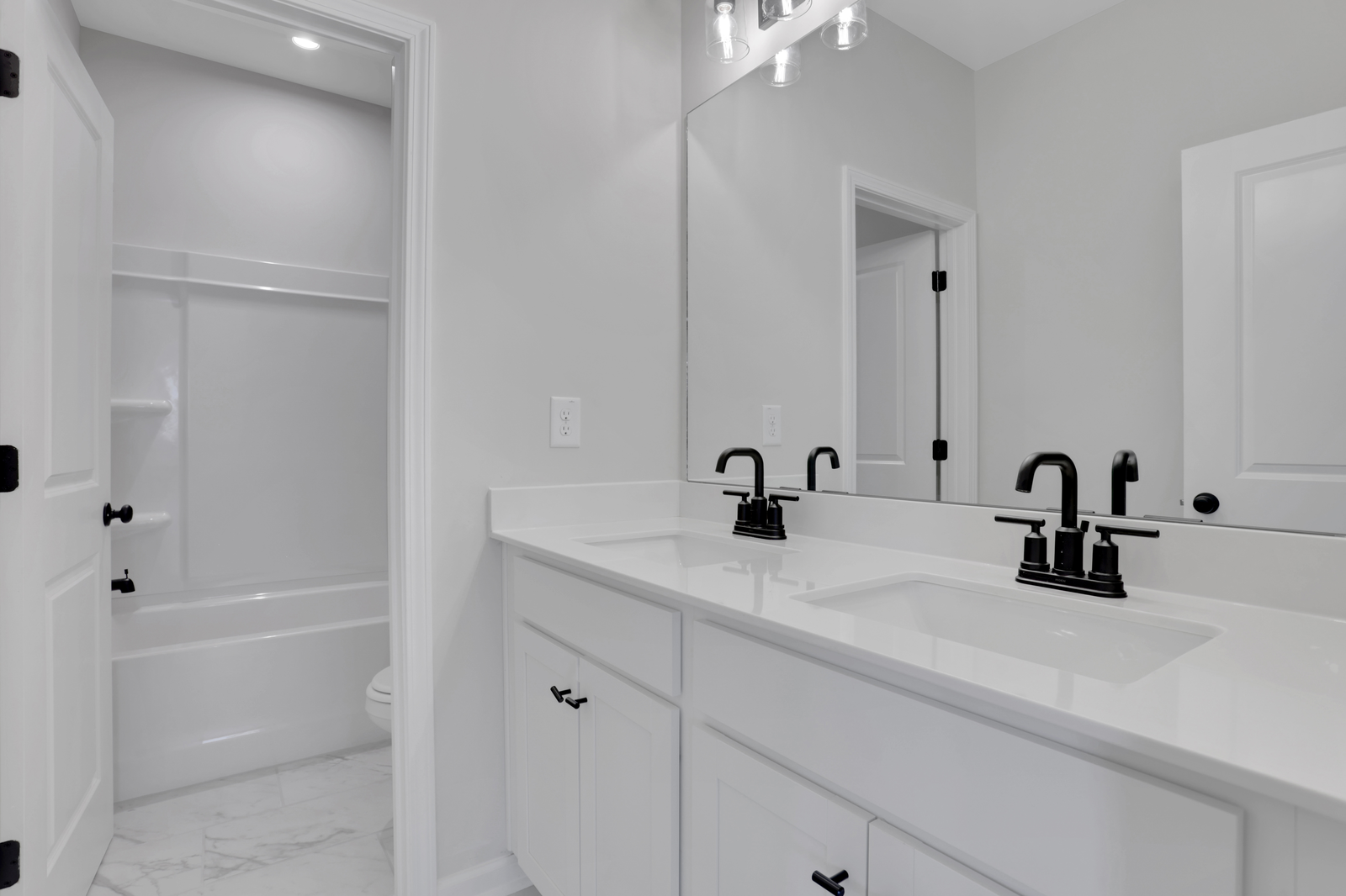 secondary bathroom with white cabinets and tile flooring