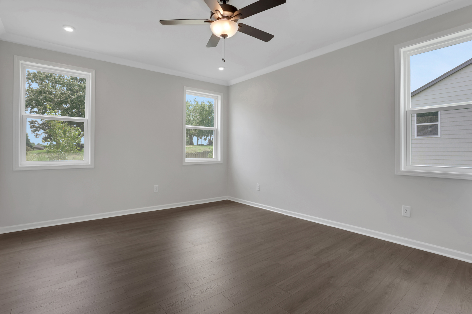 primary bedroom with windows and hard surface floors