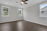 primary bedroom with windows and hard surface floors