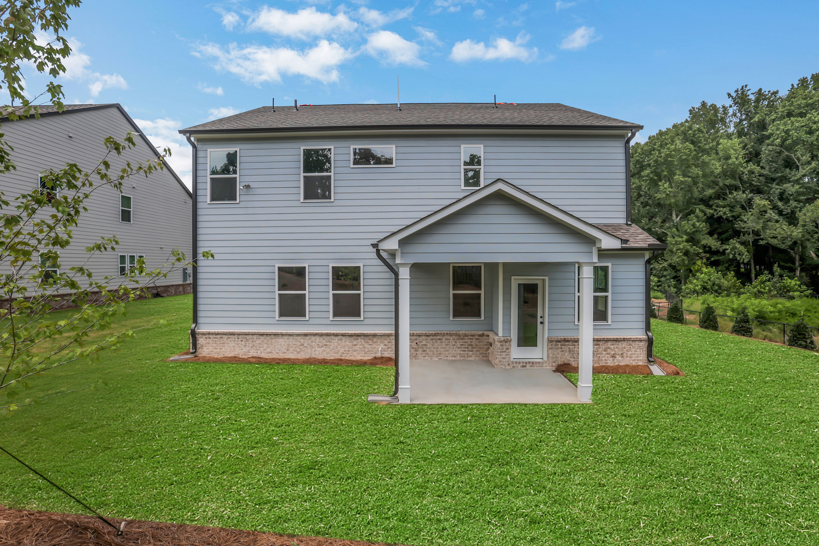back of 2-story home on a basement with covered deck