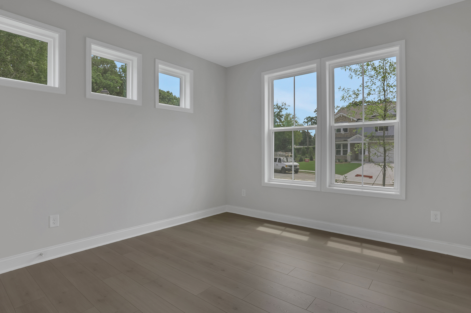 secondary bedroom with hard surface floors and windows