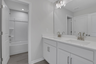 secondary bathroom with white cabinets and tile flooring