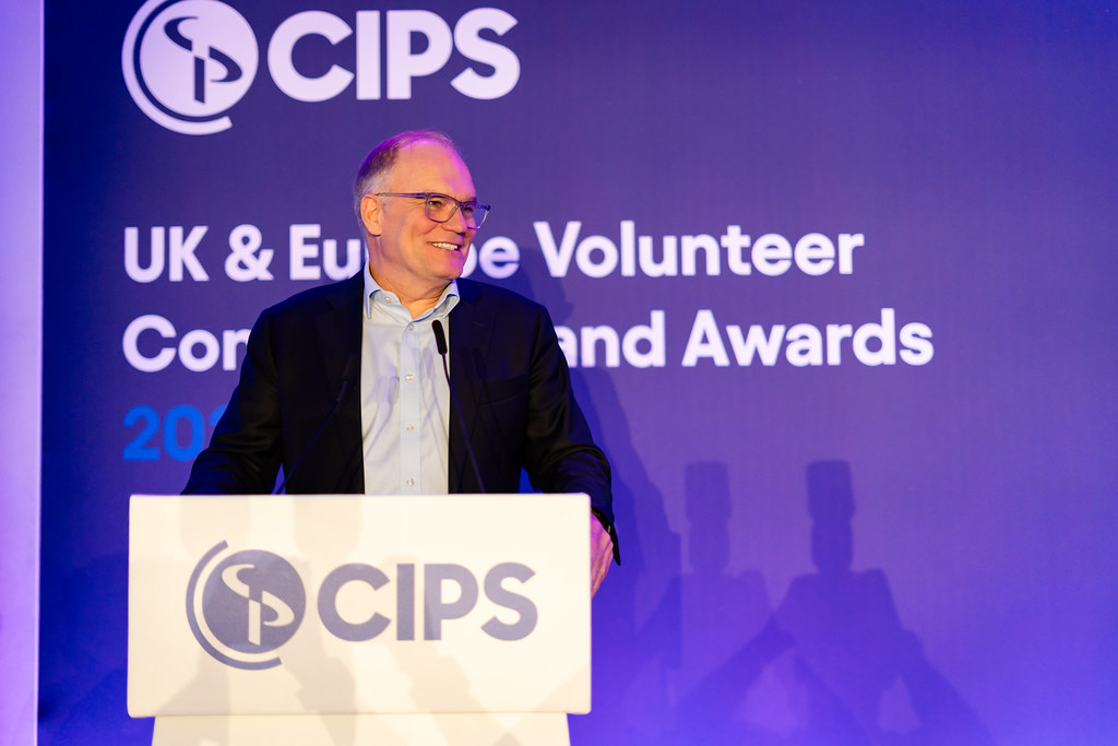 Ben Farrell, CIPS CEO, giving a presentation, standing on a stage 