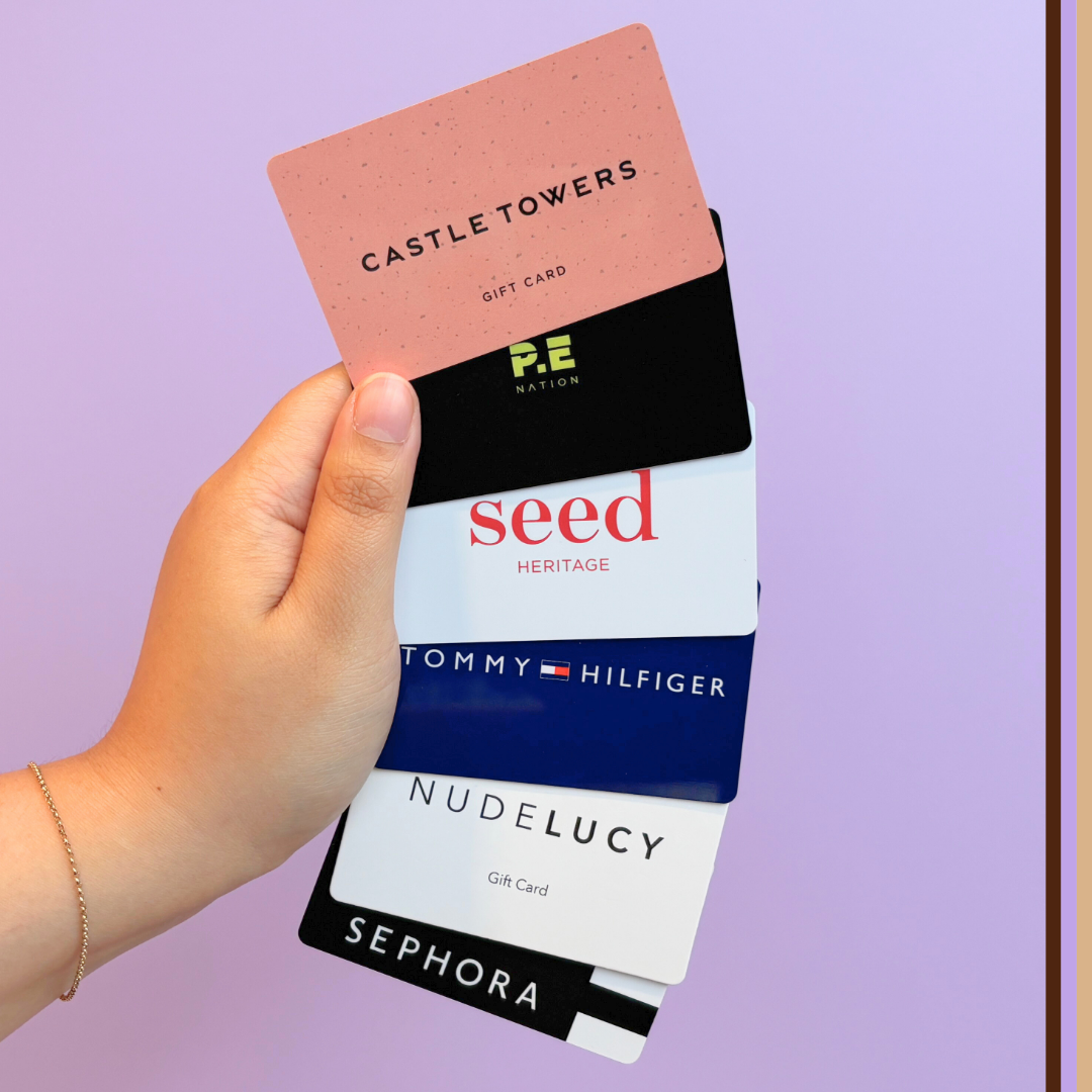 hand holding Castle Towers, P.E Nation, Seed Heritage, Tommy Hilfiger, Nude Lucy and Sephora gift cards