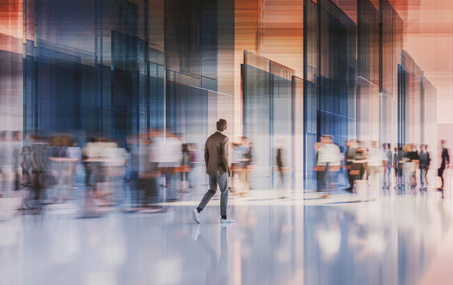 People walking in motion in blurred glass office