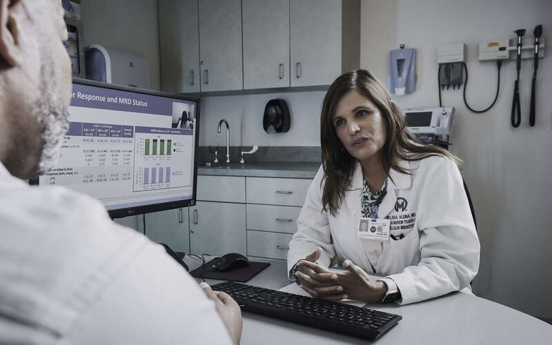 Dr. Melissa Alsina in the BMT-CI Program talks to a patient 