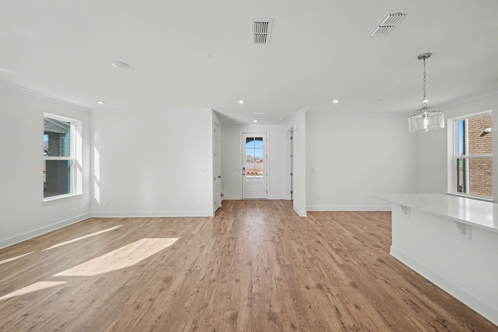 great room with large windows and wood flooring
