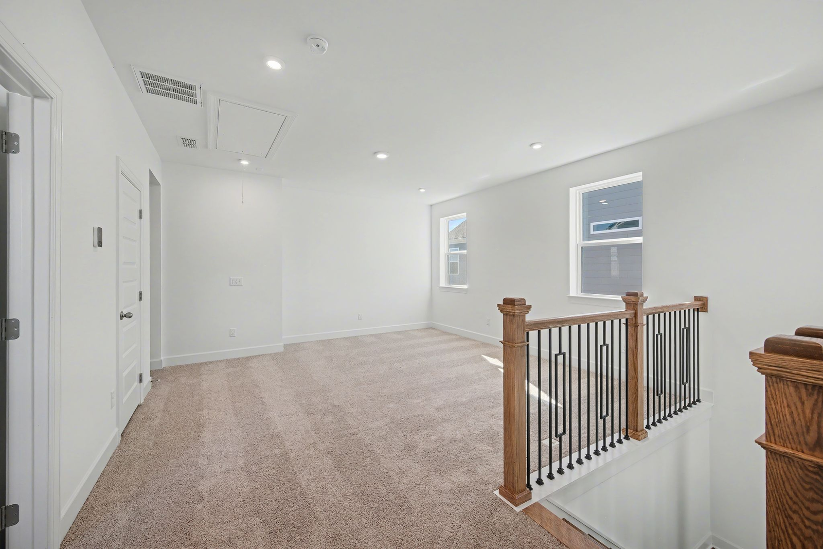 loft with carpet and large windows 