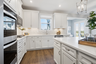 kitchen with white countertops, white cabinets, stainless steel appliances and hardwood floors