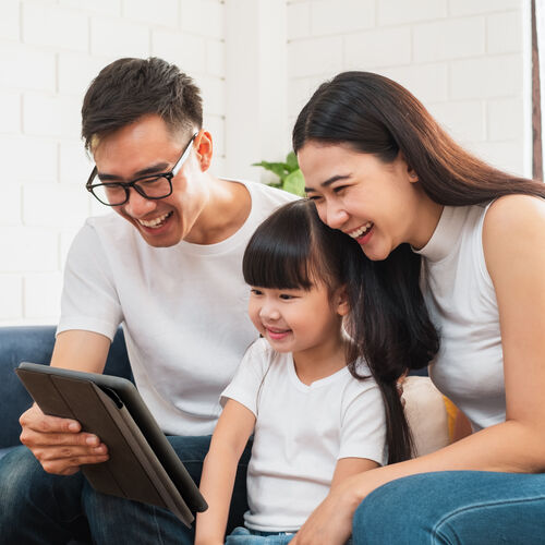 Famille sur un canapé regardant une tablette