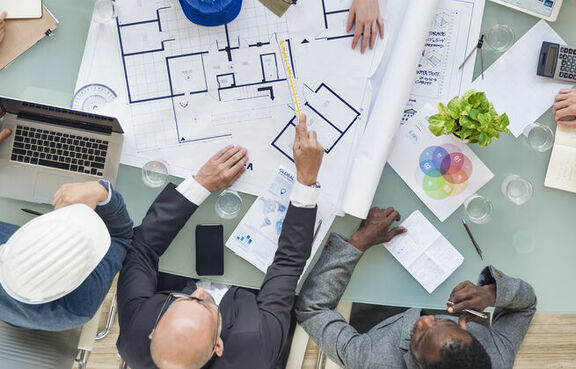 Group of architects and engineers looking over building plans 