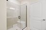 primary bathroom with tile shower and dual vanity sinks