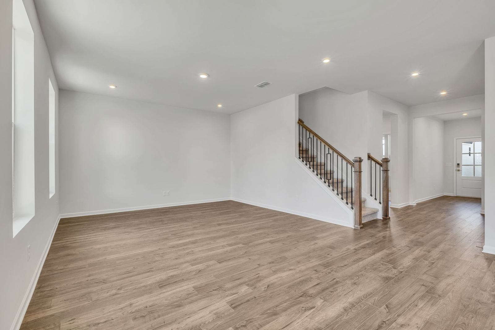 great room with wood flooring and large windows