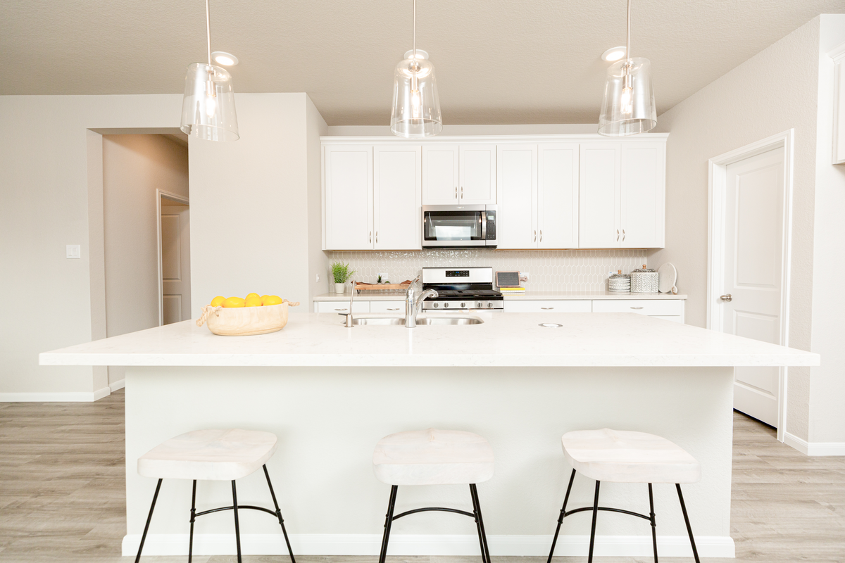 kitchen with white cabinetry & pendant lights