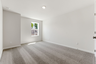 secondary bedroom with large windows, walk in closet, and carpet