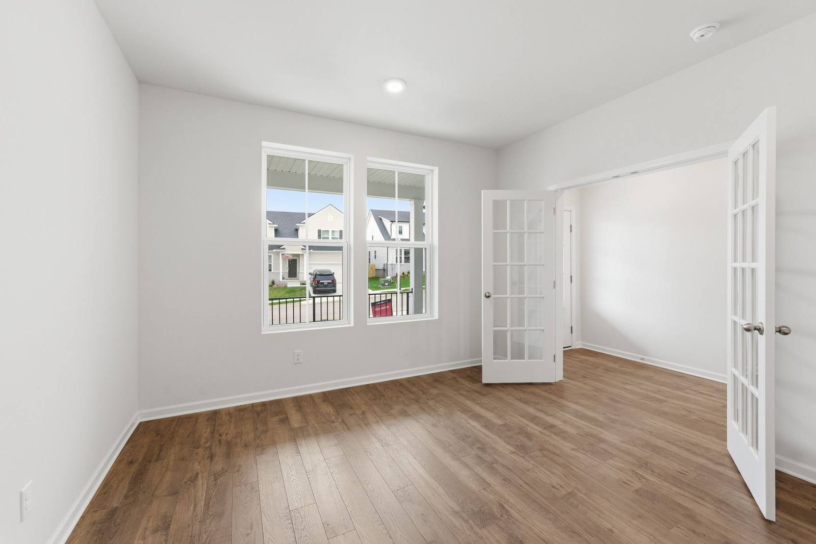 study with wood floors, large windows, and french doors