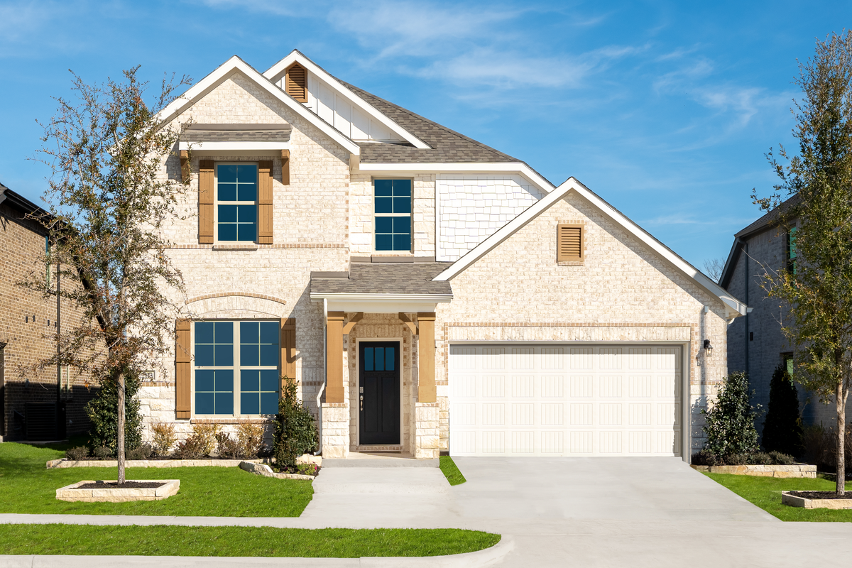 brick and stone exterior with tree in front yard