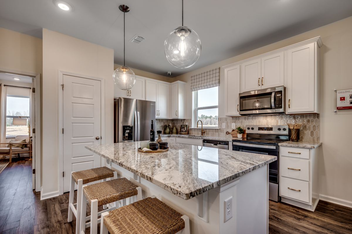 great room with white cabinets and large island