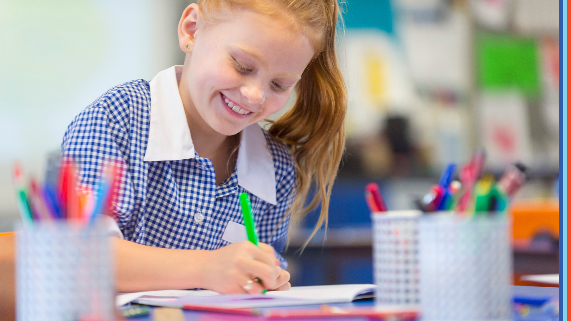 A schoolgirl is working at a desk. She is wearing a school uniform. She is writing or drawing with a felt pen. She is smiling and happy having fun.
