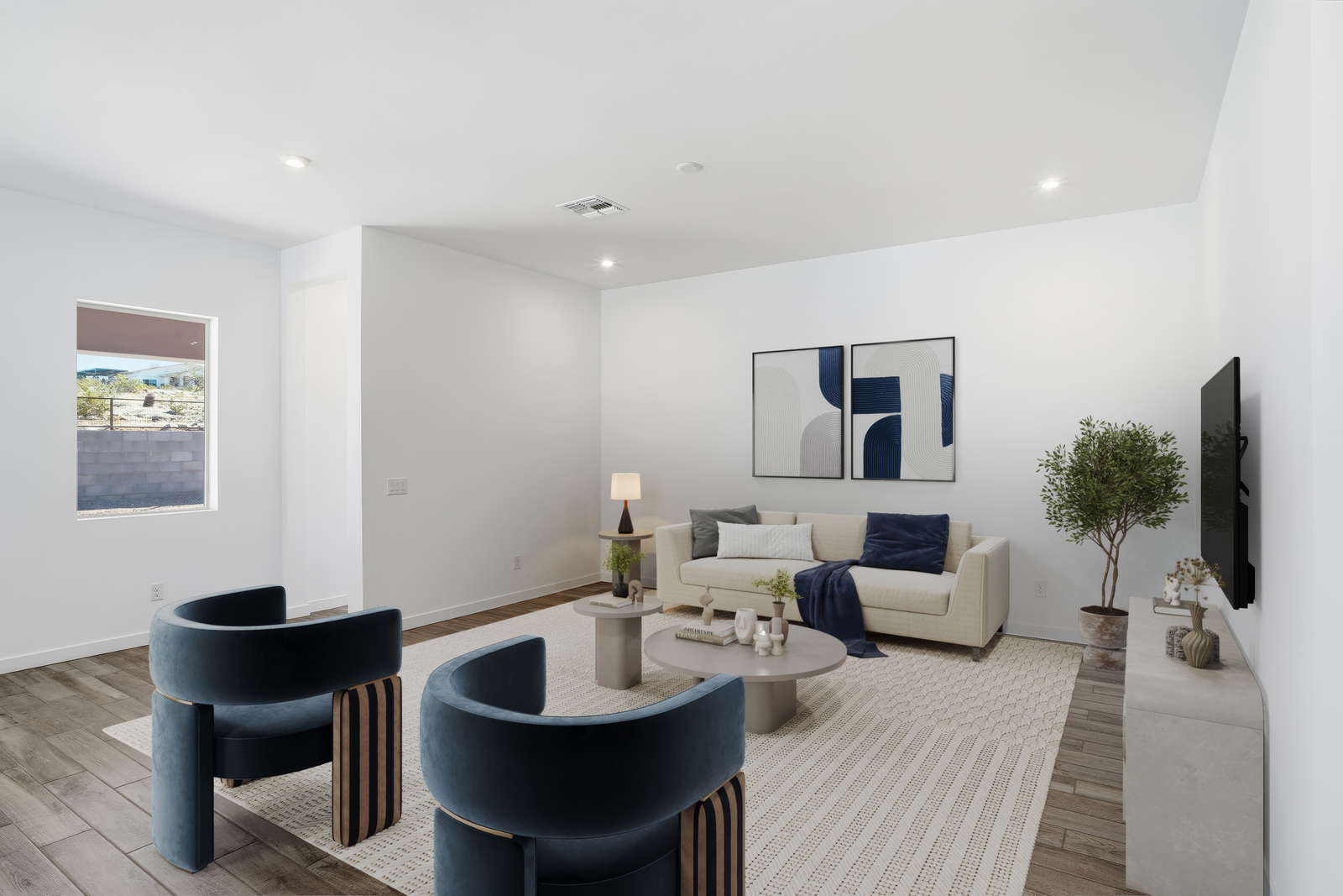 open-concept space with large white couch, grey coffee table, and navy-blue accent chairs