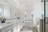 spacious bathroom with white countertops and black hardware