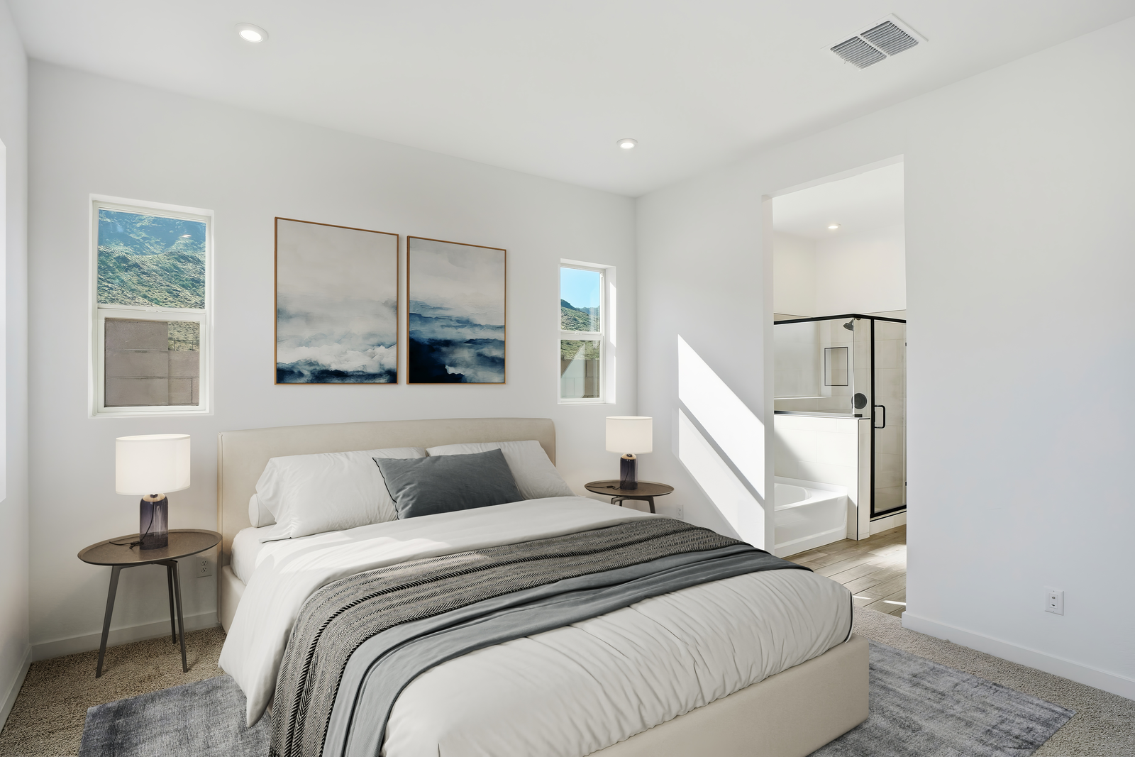 spacious bedroom with large bed, wooden nightstands, and ocean artwork