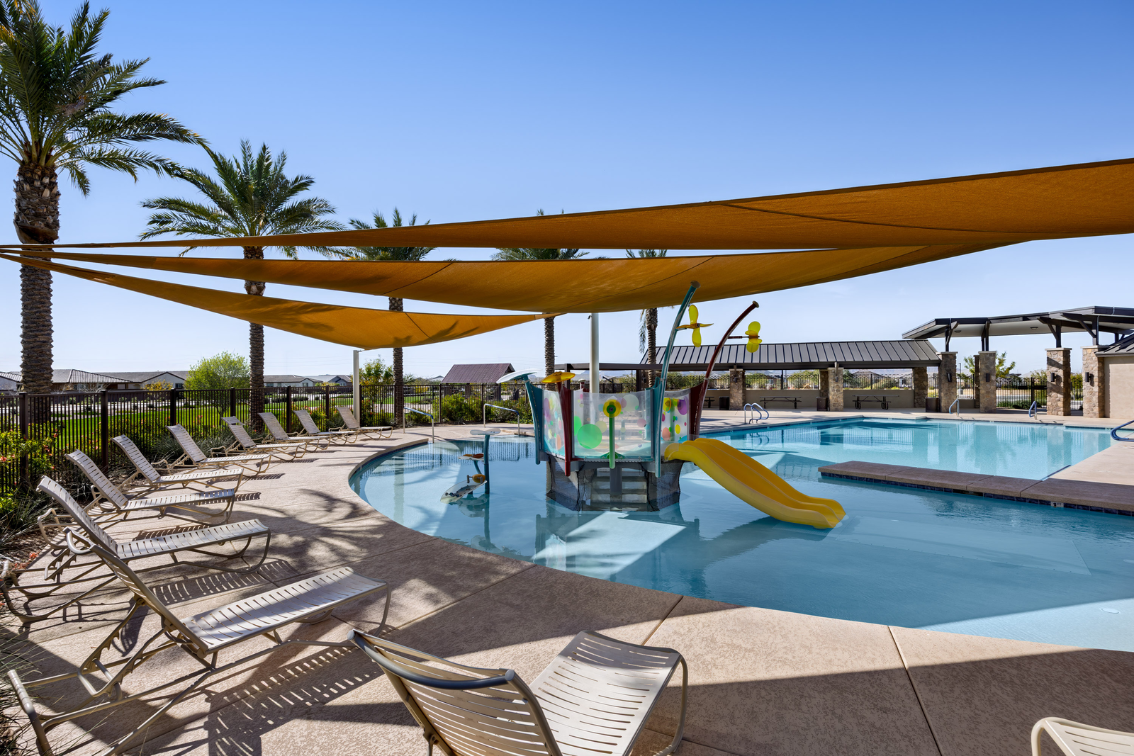 large resort-style pool with shaded cover and plenty of outdoor lounging space