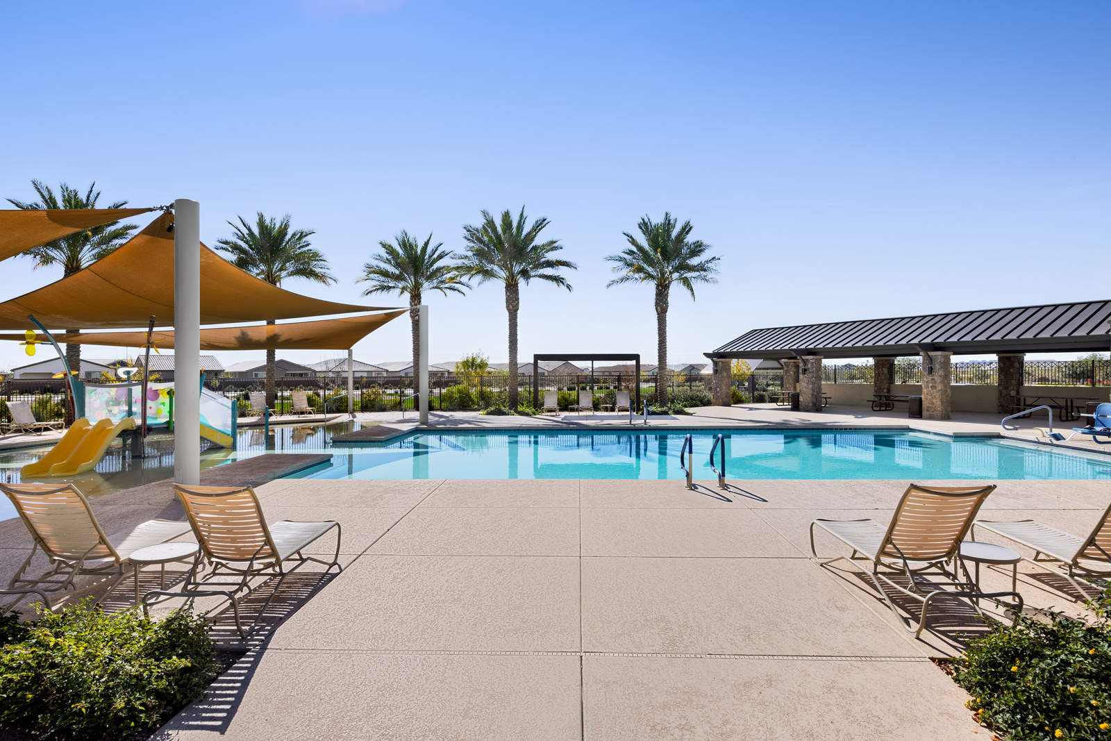 large resort-style pool with shaded cover and plenty of outdoor lounging space