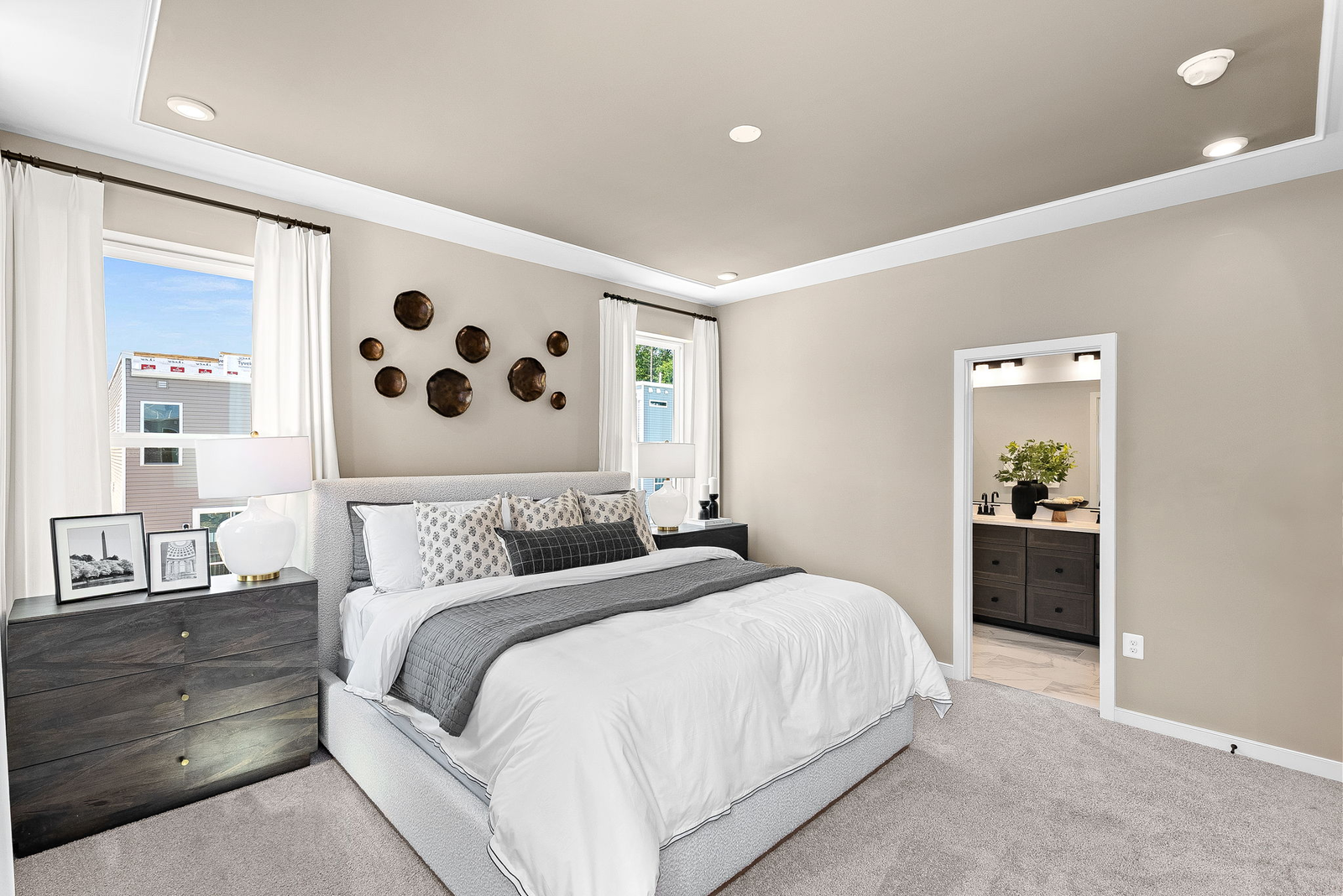 bedroom with carpet, large bed and dresser beside bed