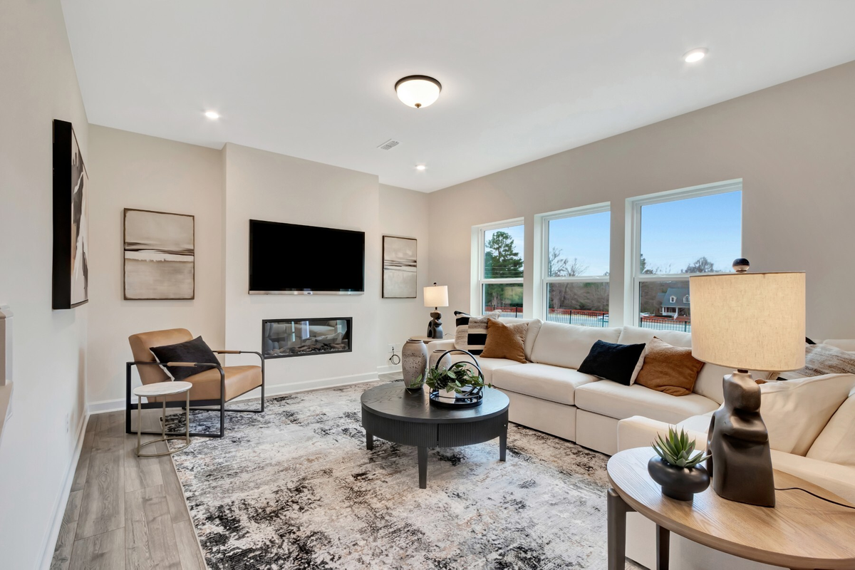 large room with linear fireplace and tv above