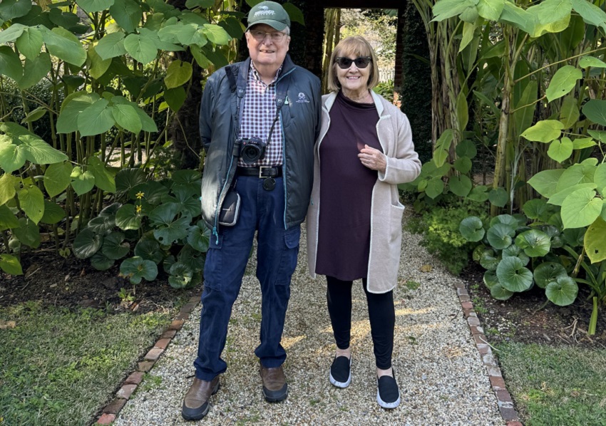 Joan and Jack on a stone path in front of greenery