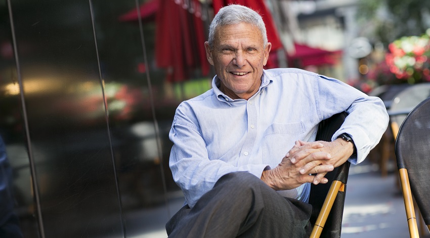 Mike Zoob smiles while sitting in an outdoor patio area