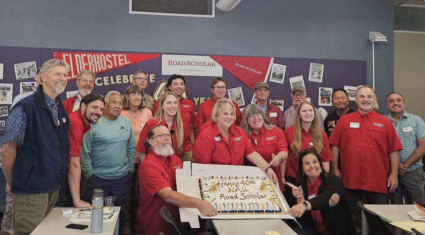 Staff pose with a cake celebrating 40 years of NAU and Road Scholar