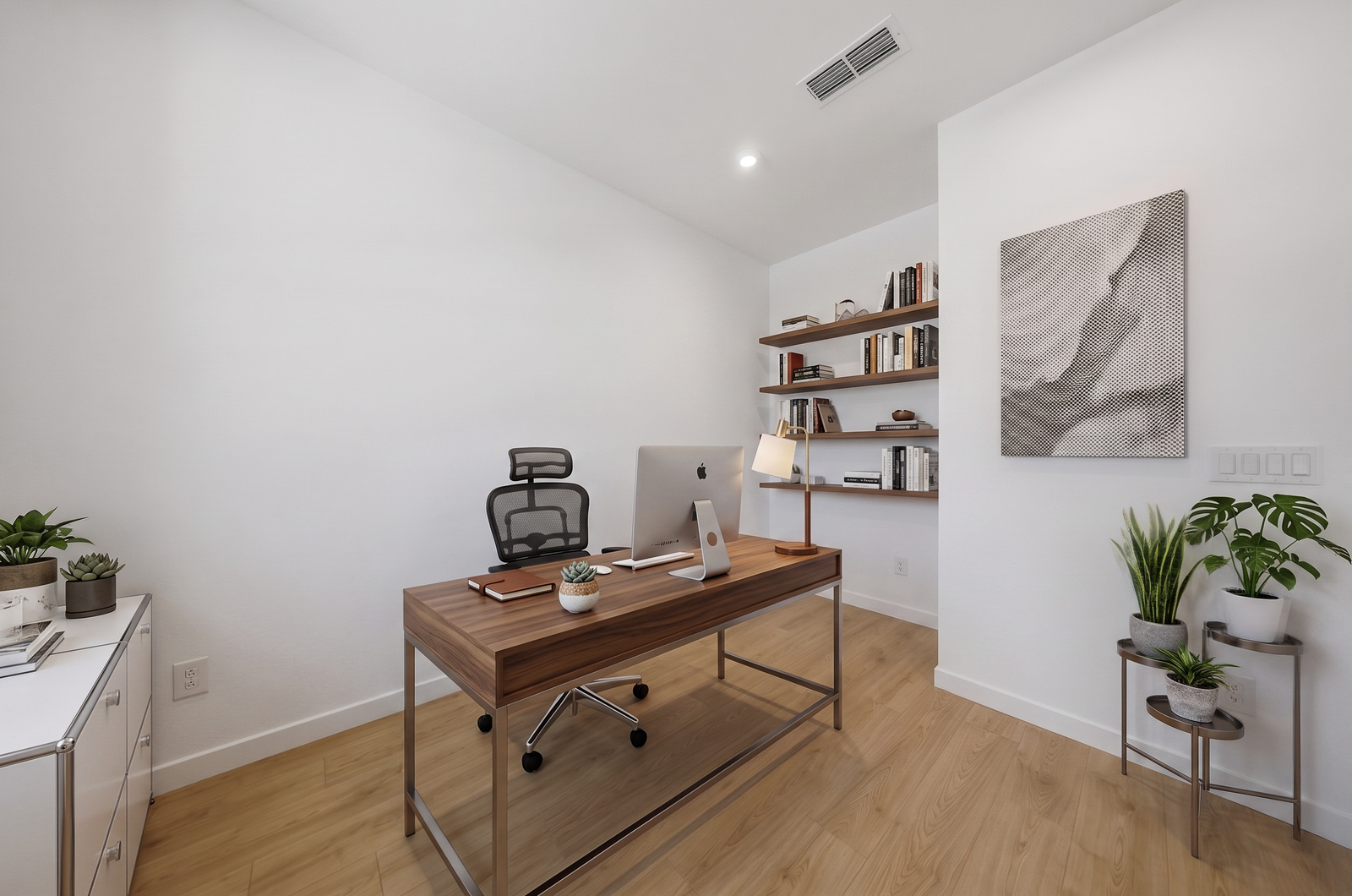 at home office with walnut desk, walnut bookshelf, and black office chair