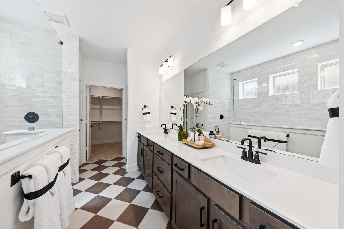 primary bathroom with two sinks and walk-in shower