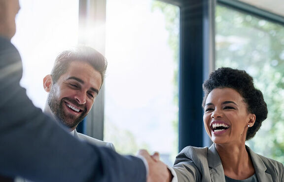 Three business people smiling handshake