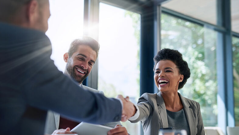 Three business people smiling handshake